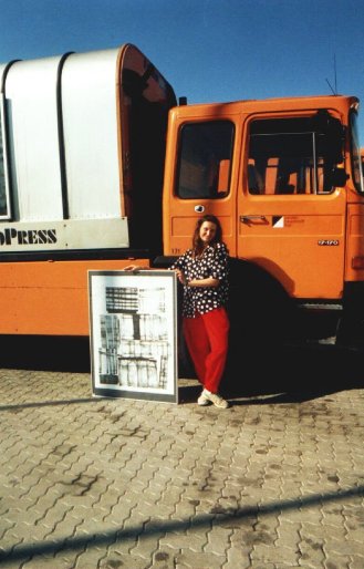 Foto der Künstlerin mit einem Materialdruck vor einem Müllwagen